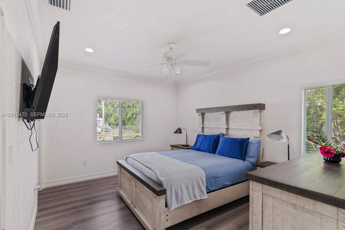 Wood-finish flooring, recessed lighting, crown molding, and dual windows