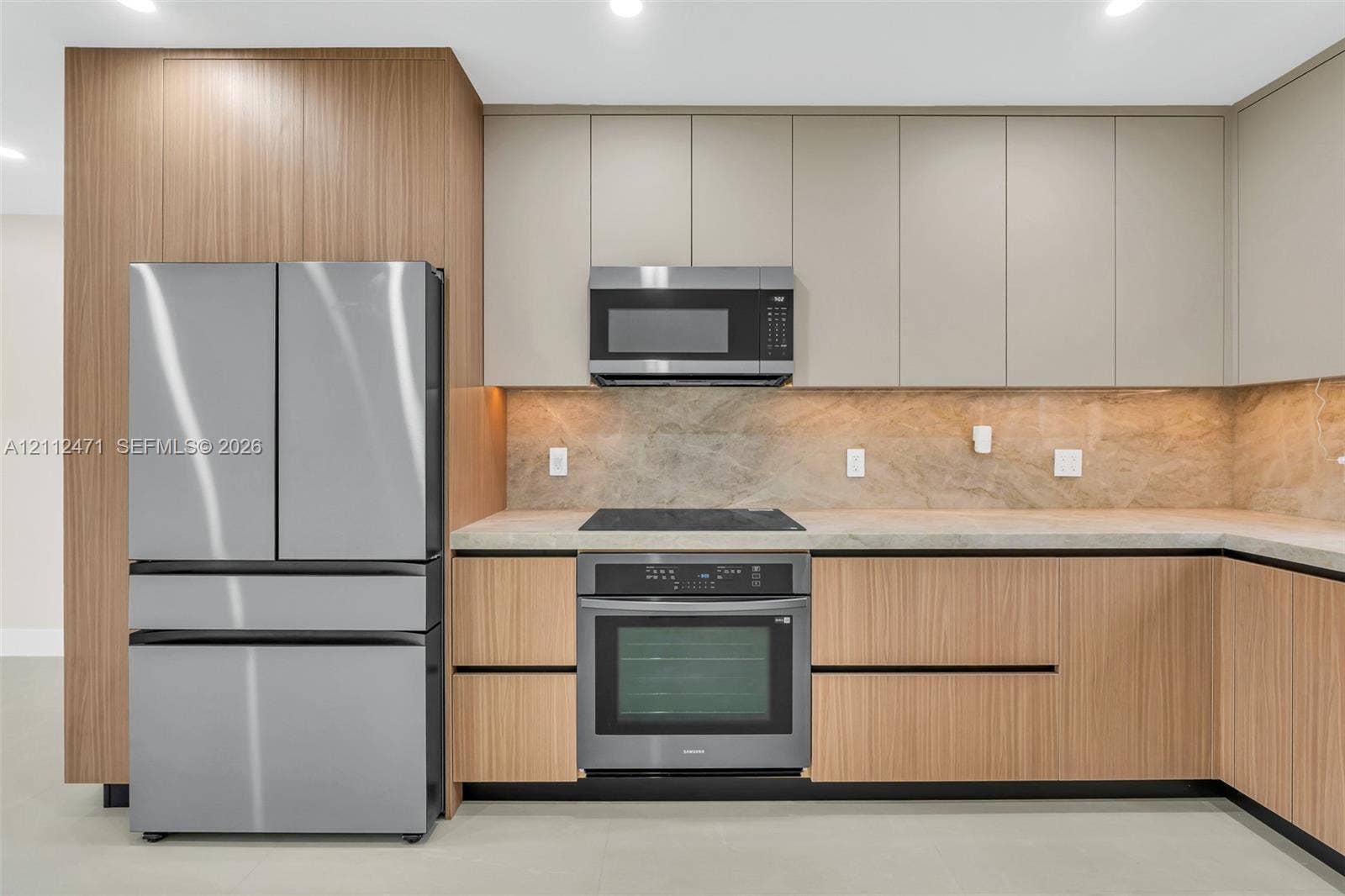 Contemporary kitchen featuring wood-finish cabinetry, neutral matte-finish upper cabinets, stone-surfaced countertops, a full-height stone backsplash, and stainless steel appliances