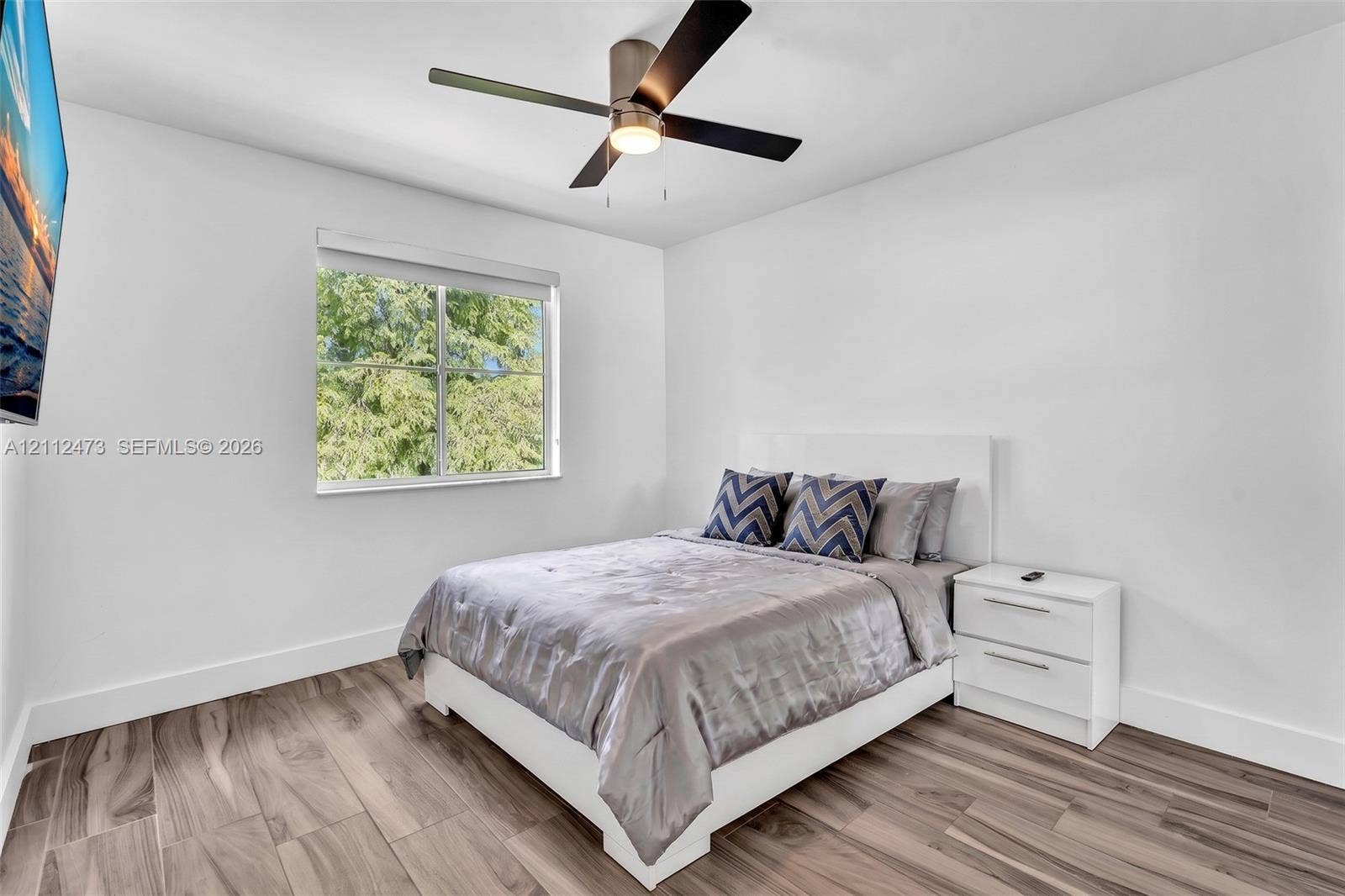 3340 SW 50th Street, Hollywood, Hollywood, FL 33312 Bedroom featuring wood-finish flooring, a contemporary ceiling fan with integrated lighting, and a single-pane window