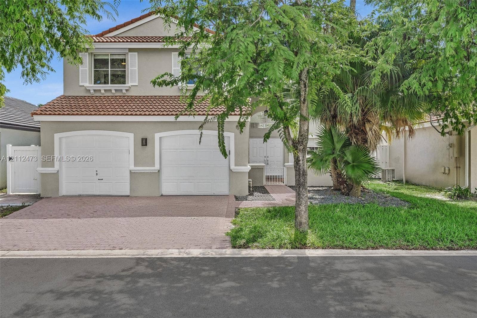 3340 SW 50th Street, Hollywood, Hollywood, FL 33312 Two-story residence featuring a tile roof, dual-bay garage, paved driveway, and double-entry doors