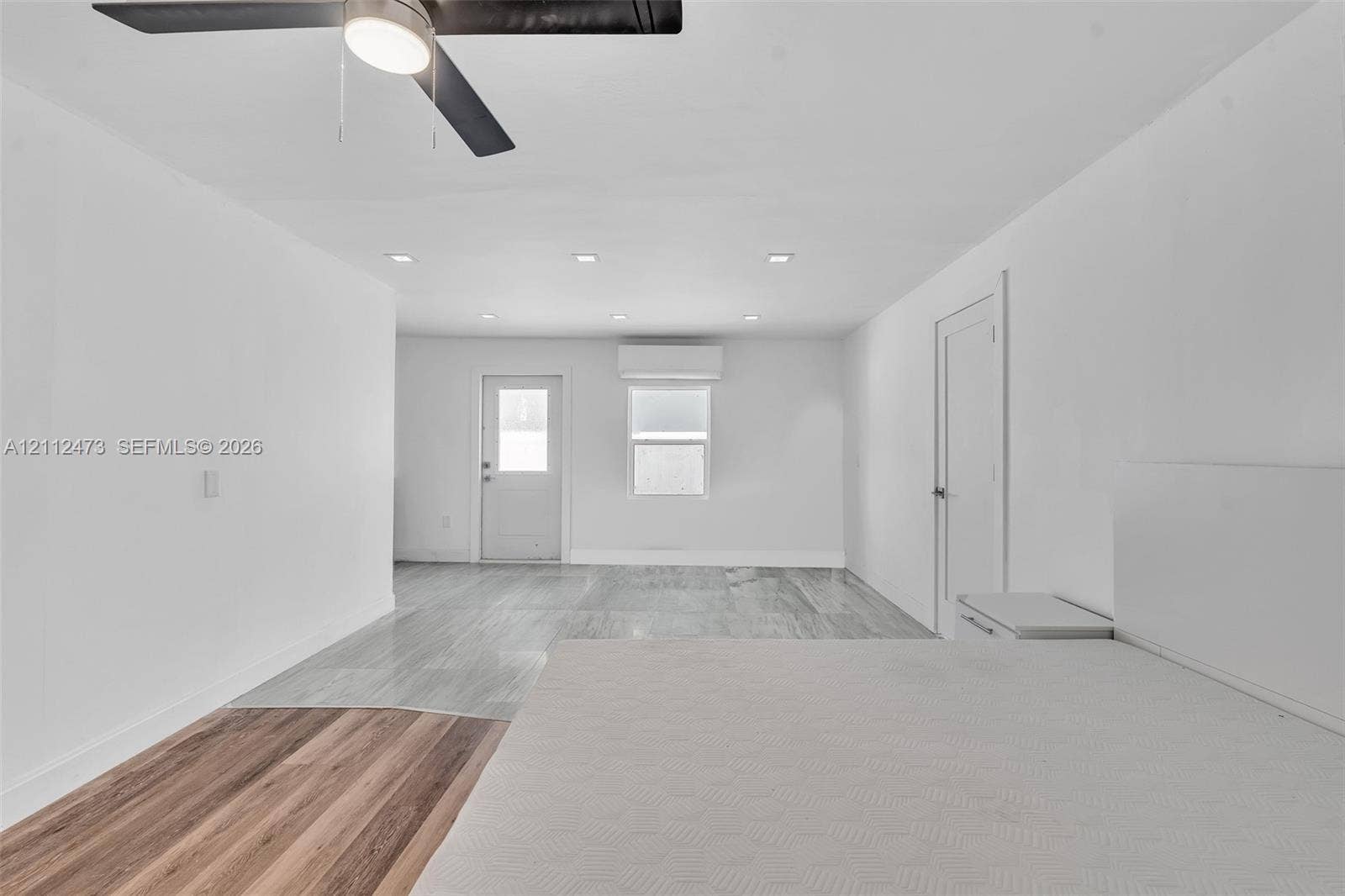 3340 SW 50th Street, Hollywood, Hollywood, FL 33312 Interior space featuring mixed-material wood-finish flooring, recessed lighting, a modern ceiling fan, and a wall-mounted climate control unit