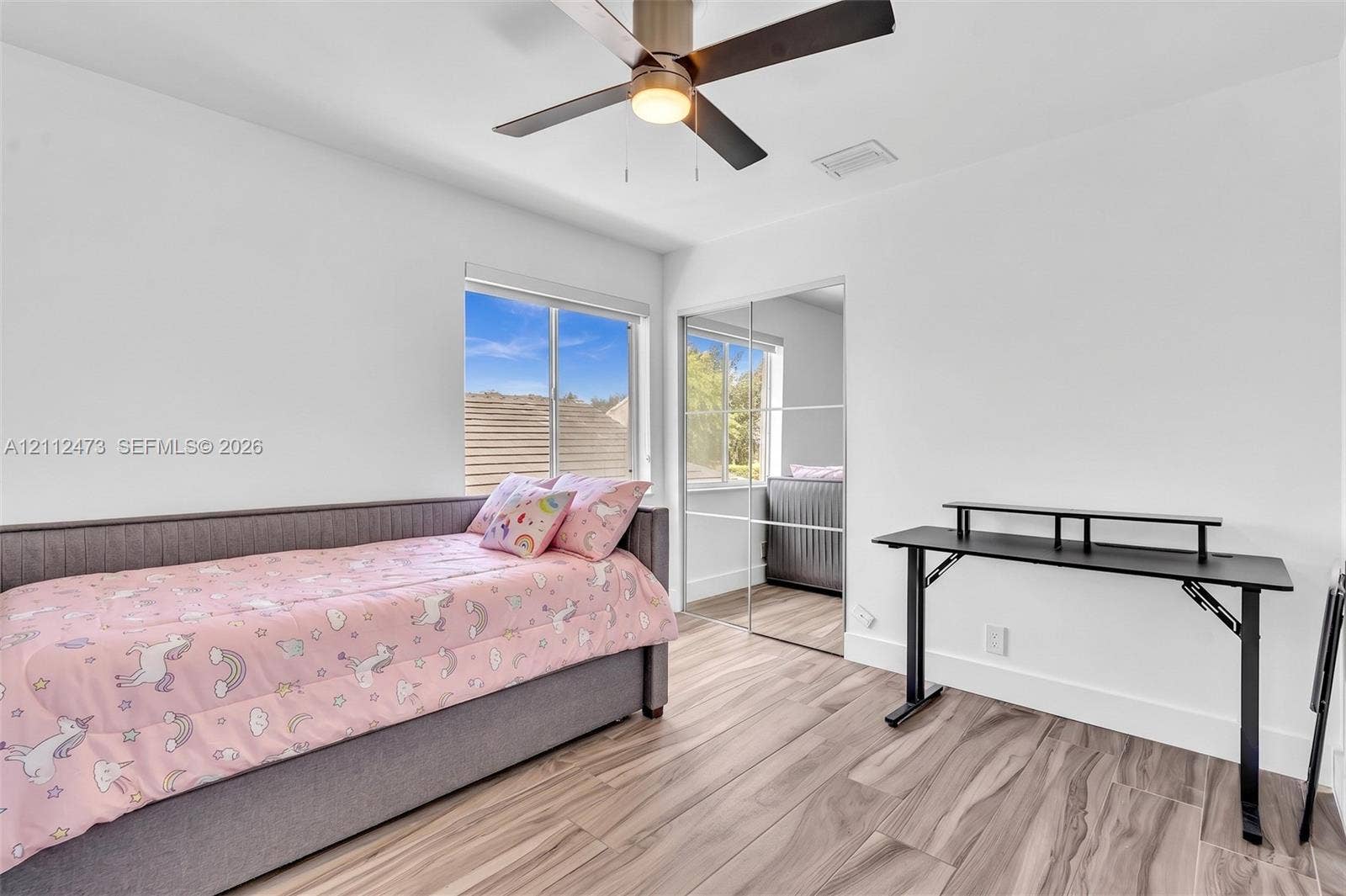 3340 SW 50th Street, Hollywood, Hollywood, FL 33312 Room featuring wood-finish flooring, a ceiling fan with integrated lighting, dual-pane windows, and a sliding mirrored closet door
