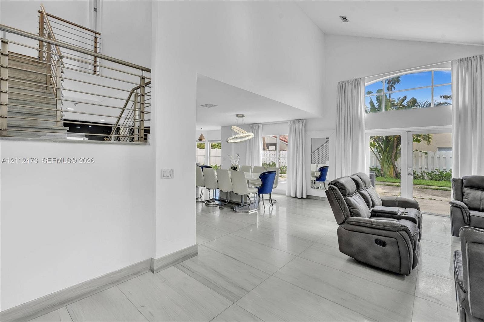 3340 SW 50th Street, Hollywood, Hollywood, FL 33312 Vaulted ceilings, large-format tile flooring, a metal stair railing, and expansive glass window panels with exterior access