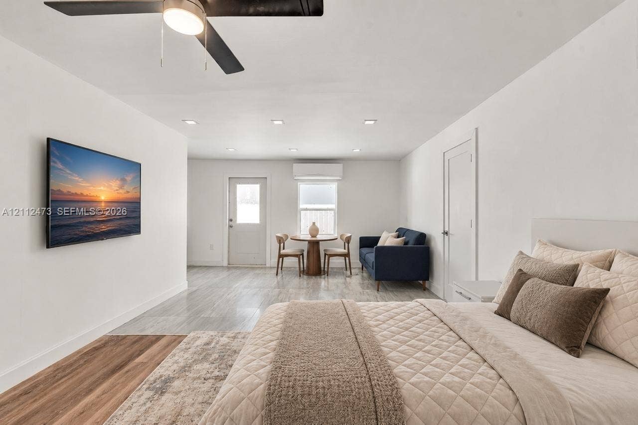 3340 SW 50th Street, Hollywood, Hollywood, FL 33312 Open-concept space featuring recessed ceiling lighting, wood-finish flooring, a wall-mounted ductless climate control unit, and a ceiling fan