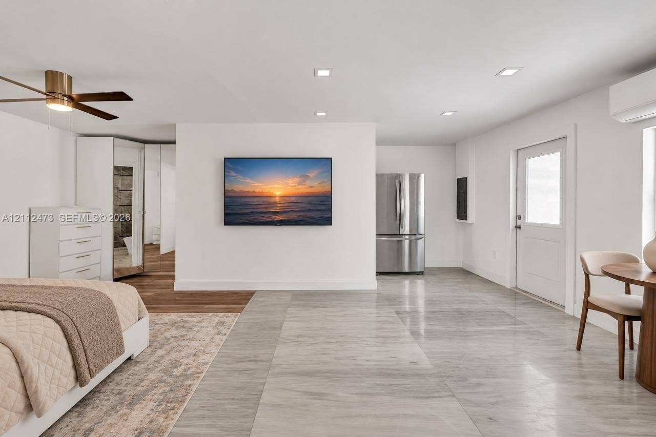 3340 SW 50th Street, Hollywood, Hollywood, FL 33312 Light-toned tile flooring, recessed ceiling lighting, brushed metallic ceiling fan, stainless steel refrigerator, and wall-mounted climate control unit