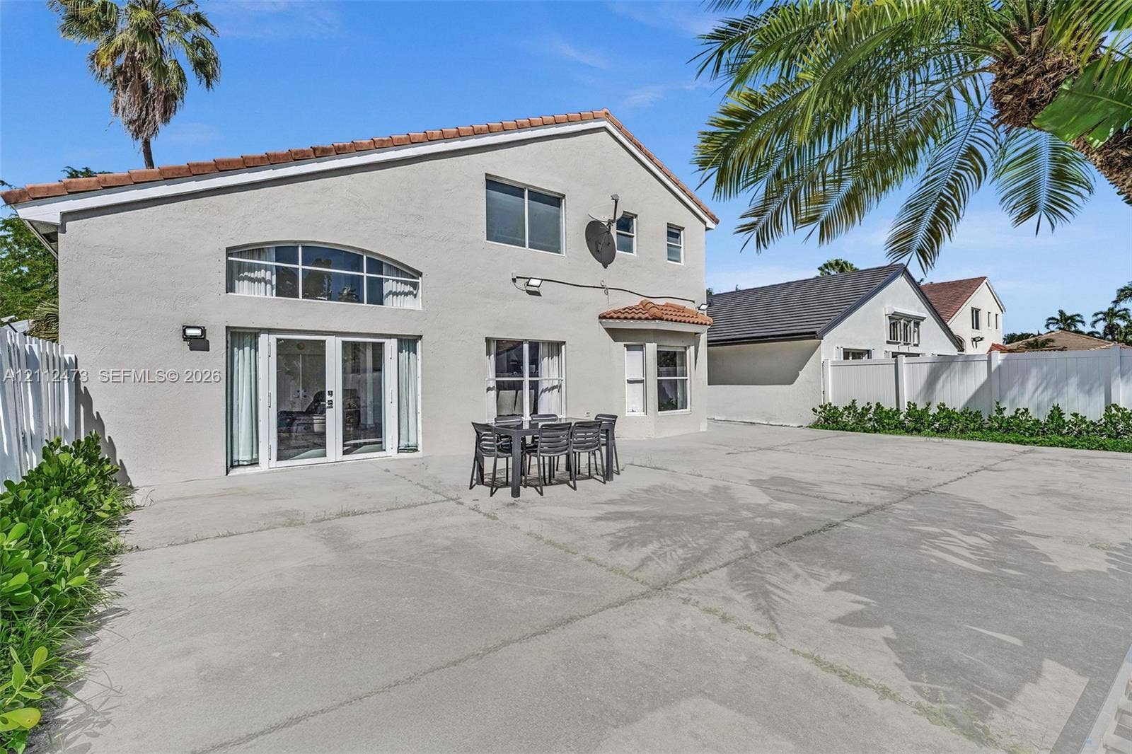 3340 SW 50th Street, Hollywood, Hollywood, FL 33312 Stucco exterior featuring a large concrete patio, arched transom window, French doors, and bay window architecture