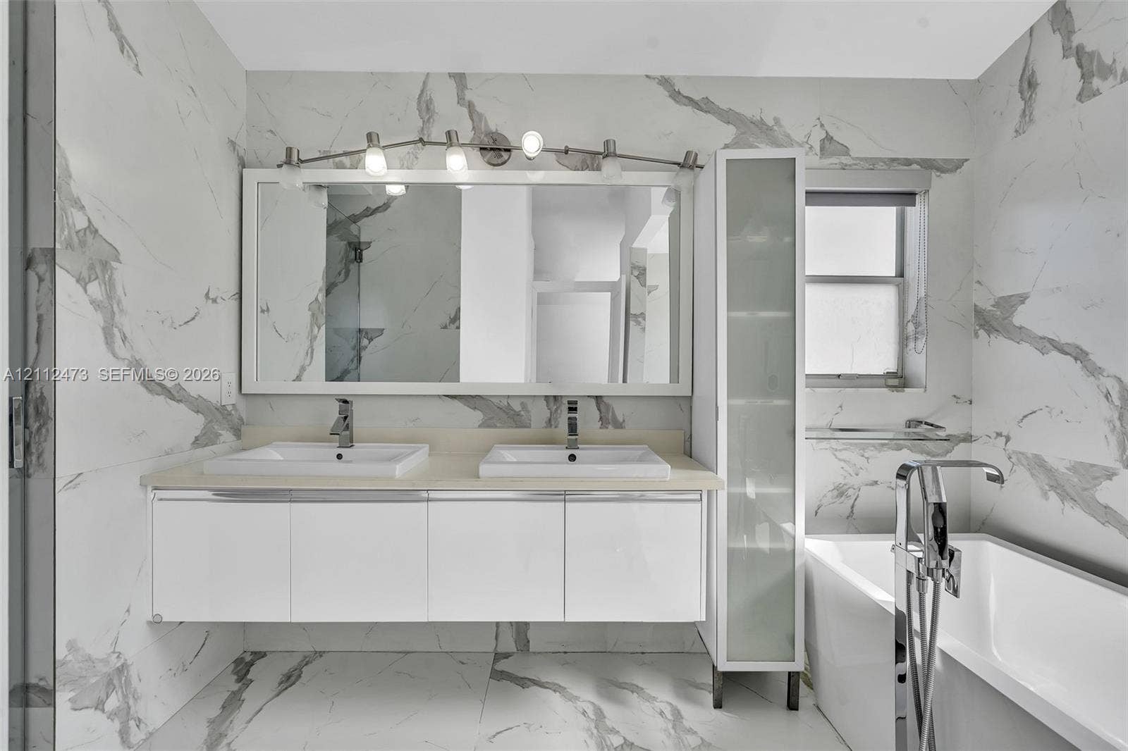 3340 SW 50th Street, Hollywood, Hollywood, FL 33312 Floating double vanity with integrated rectangular sinks, stone-finish countertop, full-height frosted glass cabinetry, and floor-to-ceiling vein-patterned tile wall cladding