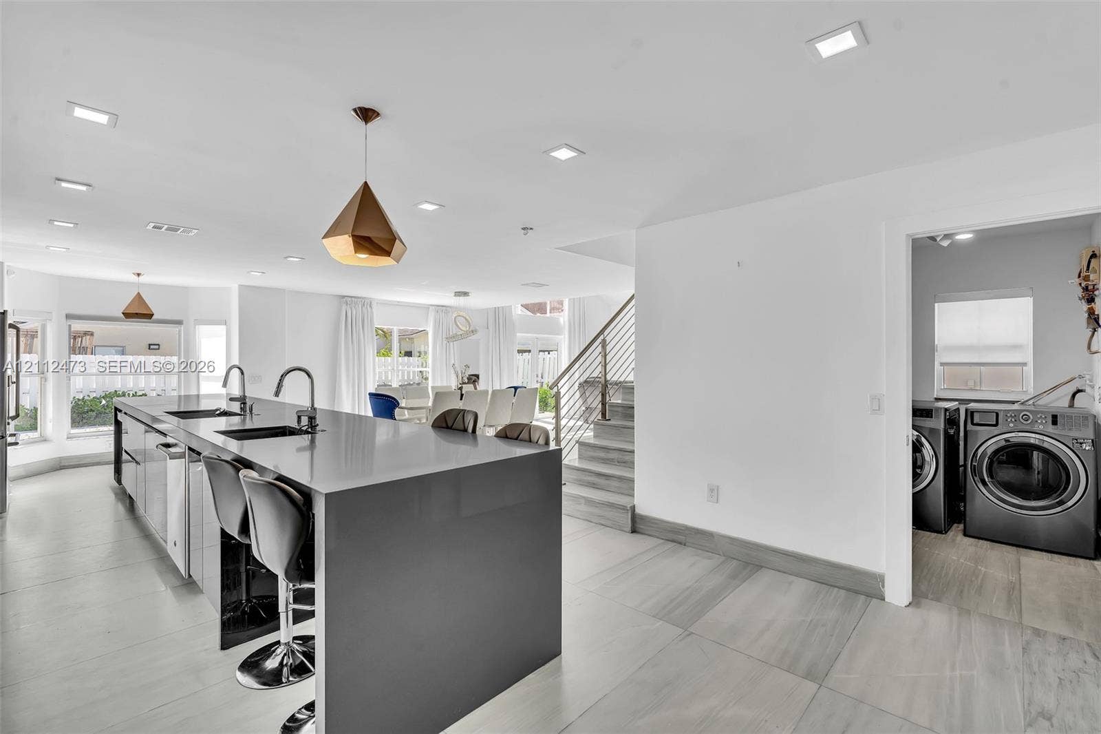 3340 SW 50th Street, Hollywood, Hollywood, FL 33312 Kitchen featuring a large island with a solid surface countertop, dual undermount sinks, geometric pendant lighting, and tile flooring