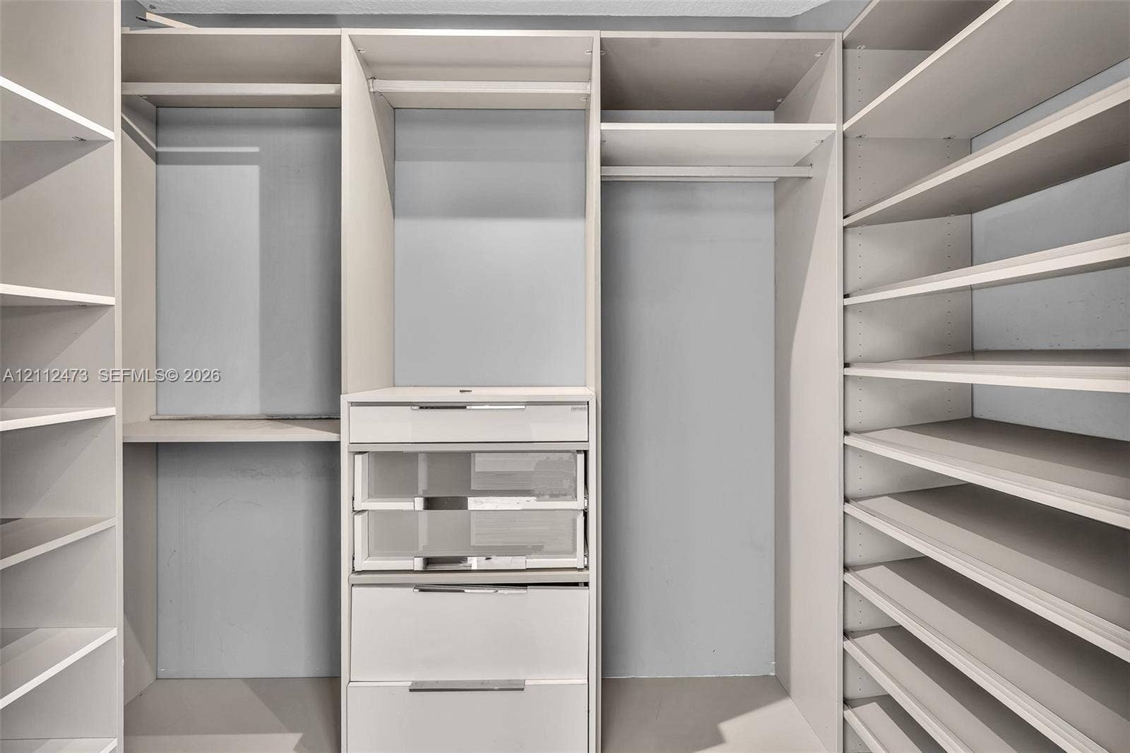 3340 SW 50th Street, Hollywood, Hollywood, FL 33312 Customized closet organization system featuring adjustable shelving, integrated garment rods, and built-in drawers with glass-front paneling