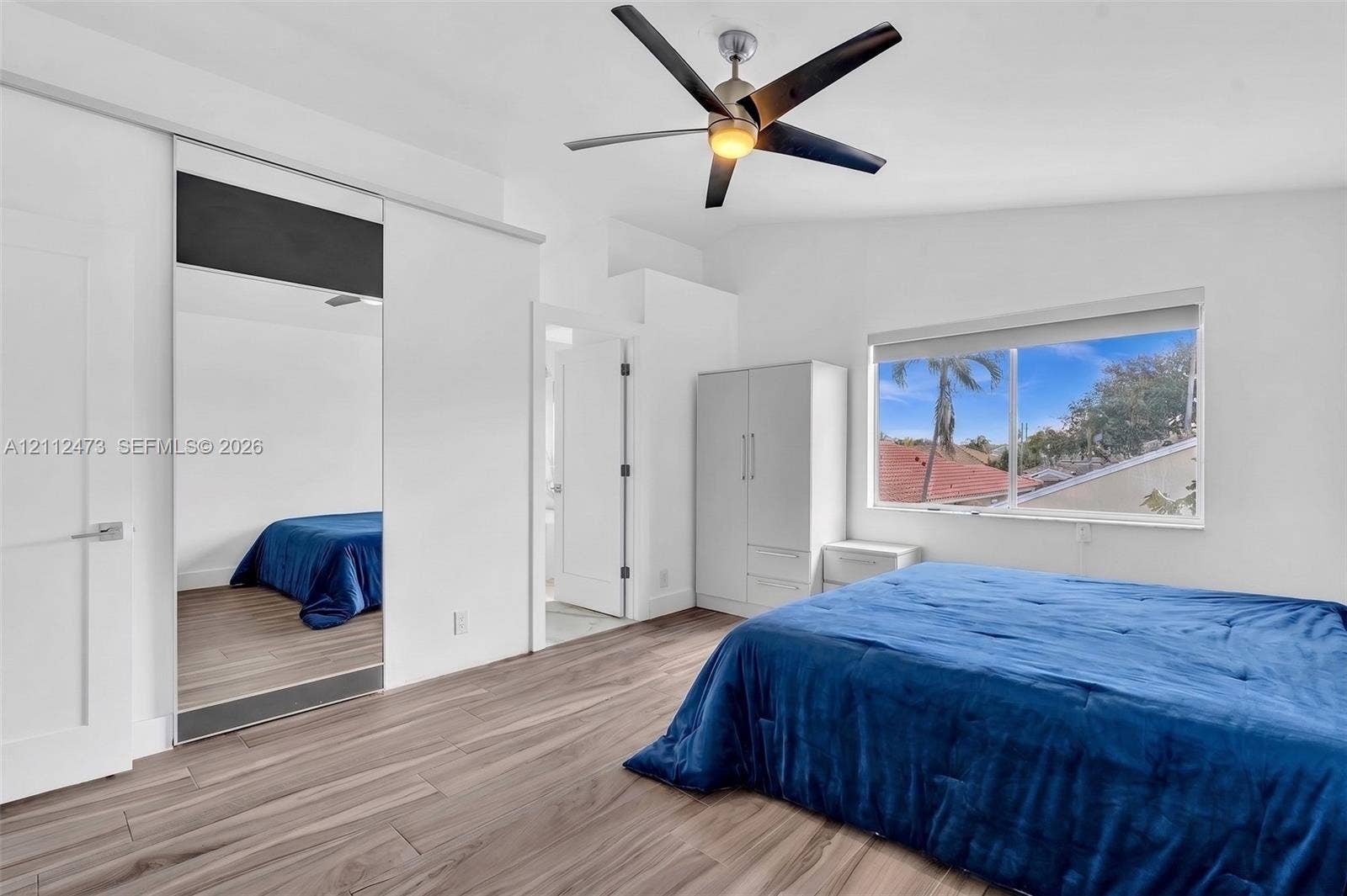 3340 SW 50th Street, Hollywood, Hollywood, FL 33312 Room featuring wood-finish flooring, vaulted ceilings, a ceiling fan, and sliding mirror-panel closet doors
