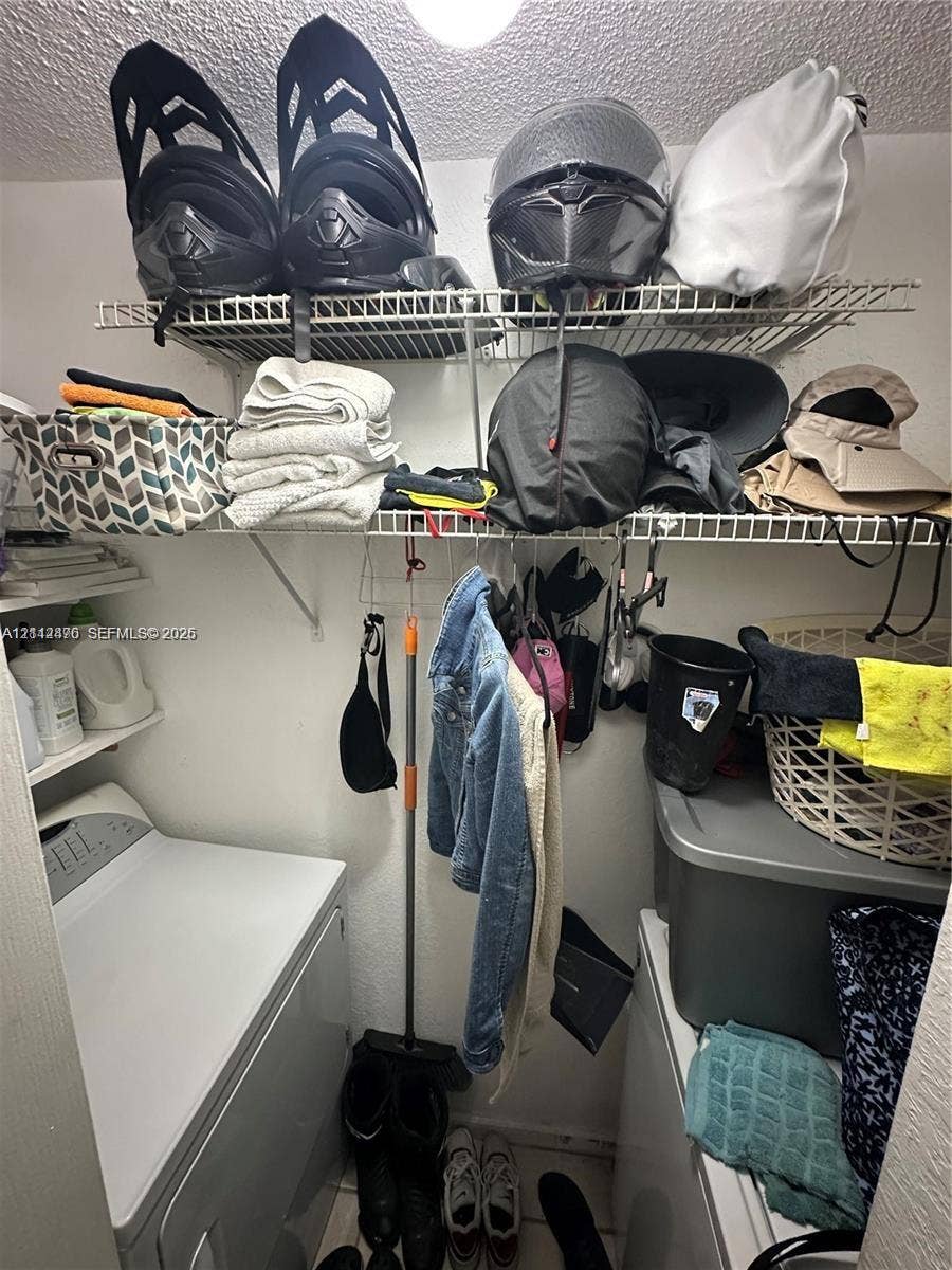 Laundry area featuring white heavy-duty wire shelving and side-by-side appliance configuration