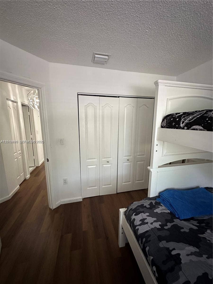 Wood-finish flooring and white bi-fold closet doors