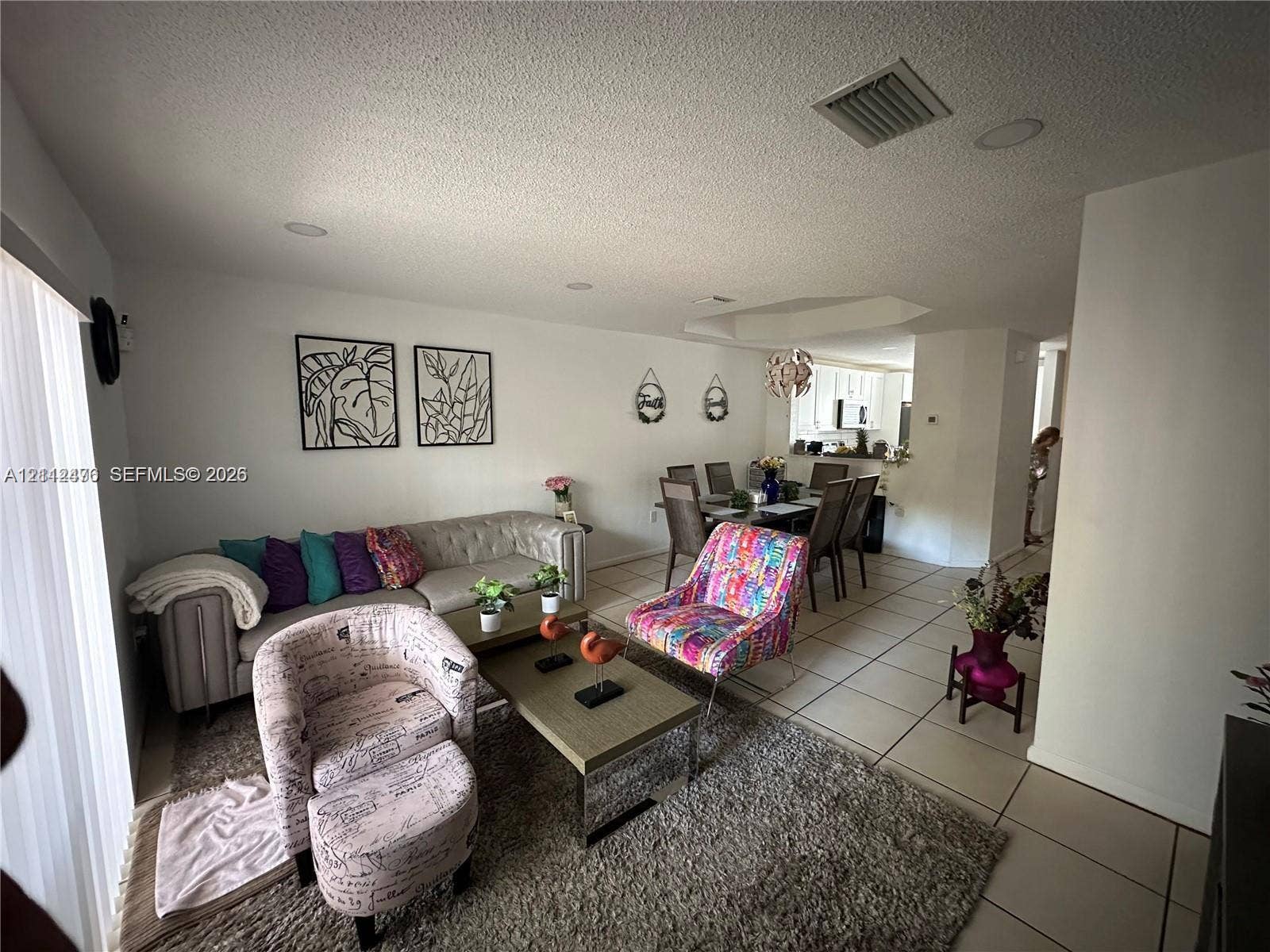 Living area featuring large-format tile flooring and recessed lighting
