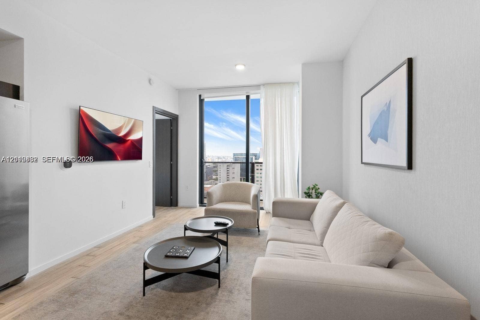 Living area featuring floor-to-ceiling windows, wood-finish flooring, and recessed ceiling lighting