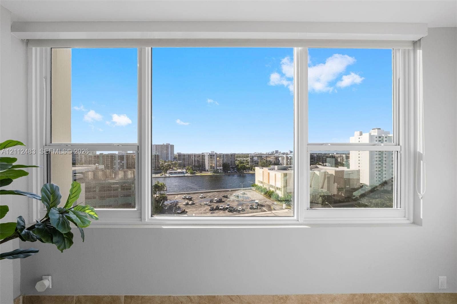 3505 S Ocean Drive, #1101, Hollywood, FL 33019 Large triple-pane window featuring white frames and a wide sill, showcasing expansive water and urban scenery