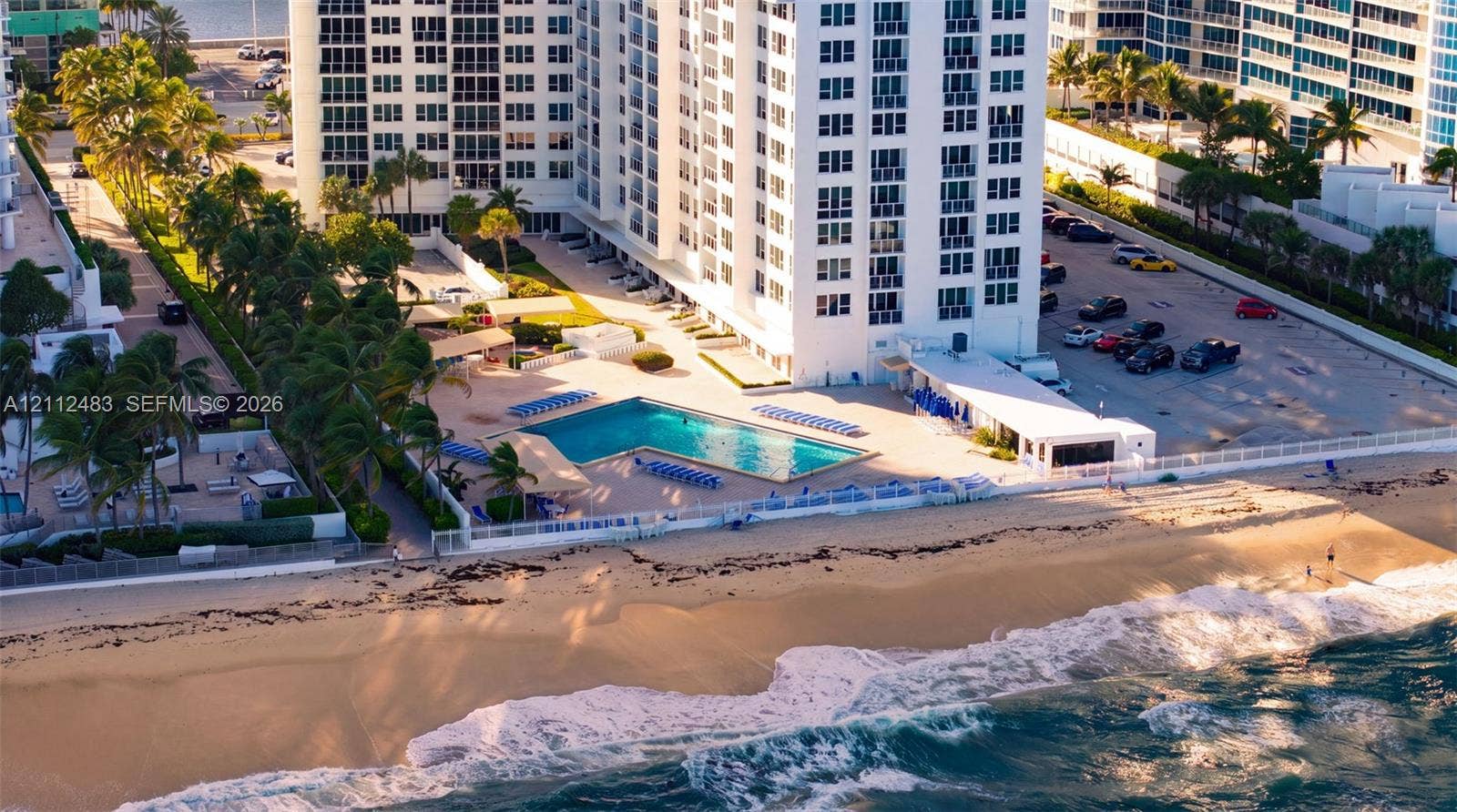 3505 S Ocean Drive, #1101, Hollywood, FL 33019 High-rise residential building featuring an L-shaped swimming pool, paved sundeck, direct beach access, and surface parking