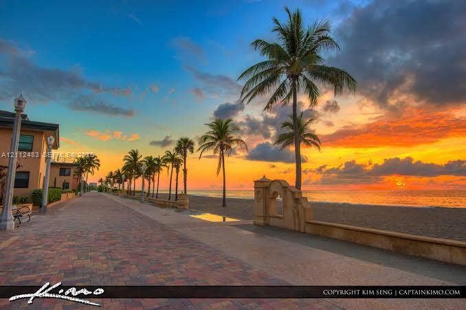 3505 S Ocean Drive, #1101, Hollywood, FL 33019 Brick-paved promenade featuring decorative lamp posts, concrete retaining walls, and mature palm trees