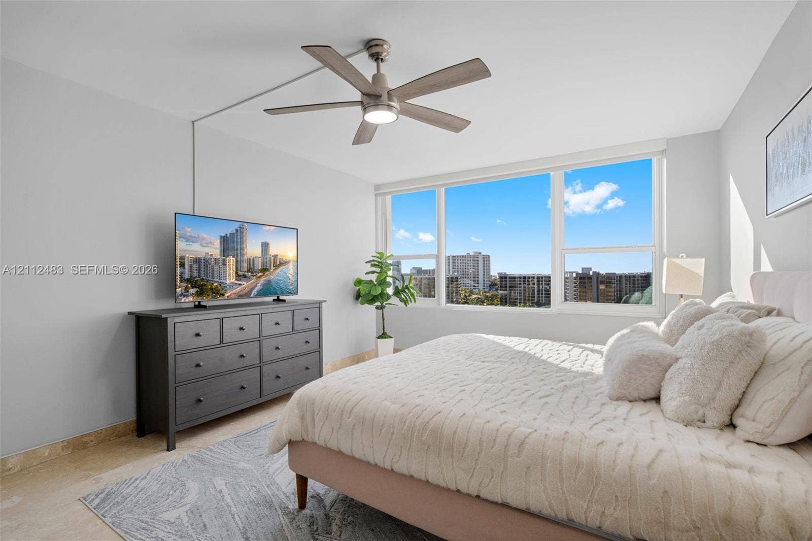 3505 S Ocean Drive, #1101, Hollywood, FL 33019 Large-format picture windows, stone-finish flooring, and a multi-blade ceiling fan with integrated lighting