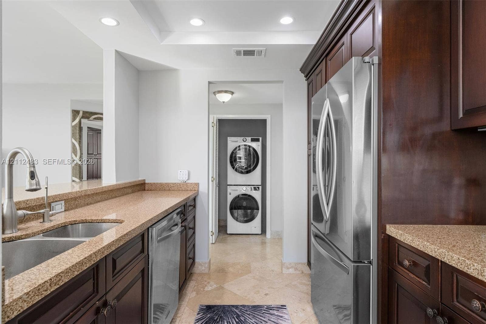 3505 S Ocean Drive, #1101, Hollywood, FL 33019 Kitchen featuring dark wood cabinetry, stone countertops, stainless steel appliances, a dual-basin undermount sink with a gooseneck faucet, and tile flooring