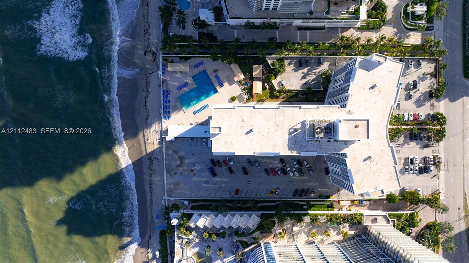 3505 S Ocean Drive, #1101, Hollywood, FL 33019 Oceanfront high-rise building featuring a swimming pool, paved surface parking, and direct beach access