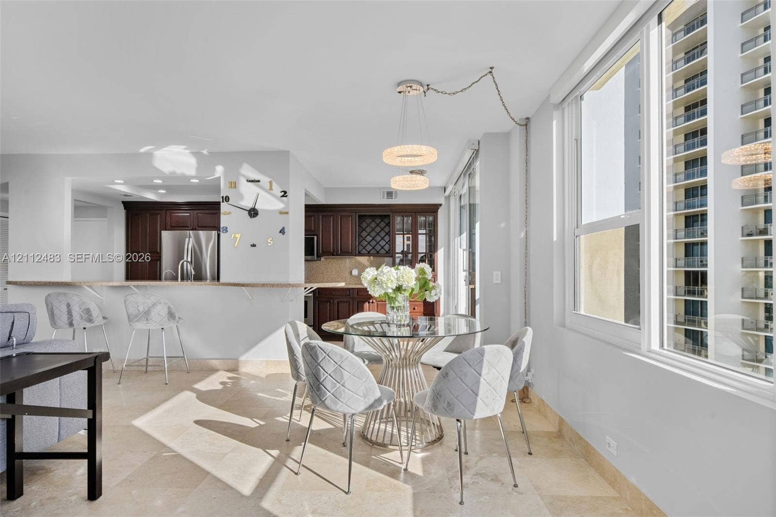 3505 S Ocean Drive, #1101, Hollywood, FL 33019 Open-concept kitchen featuring dark wood cabinetry, a pass-through breakfast bar with a stone countertop, stone flooring, and dual pendant light fixtures