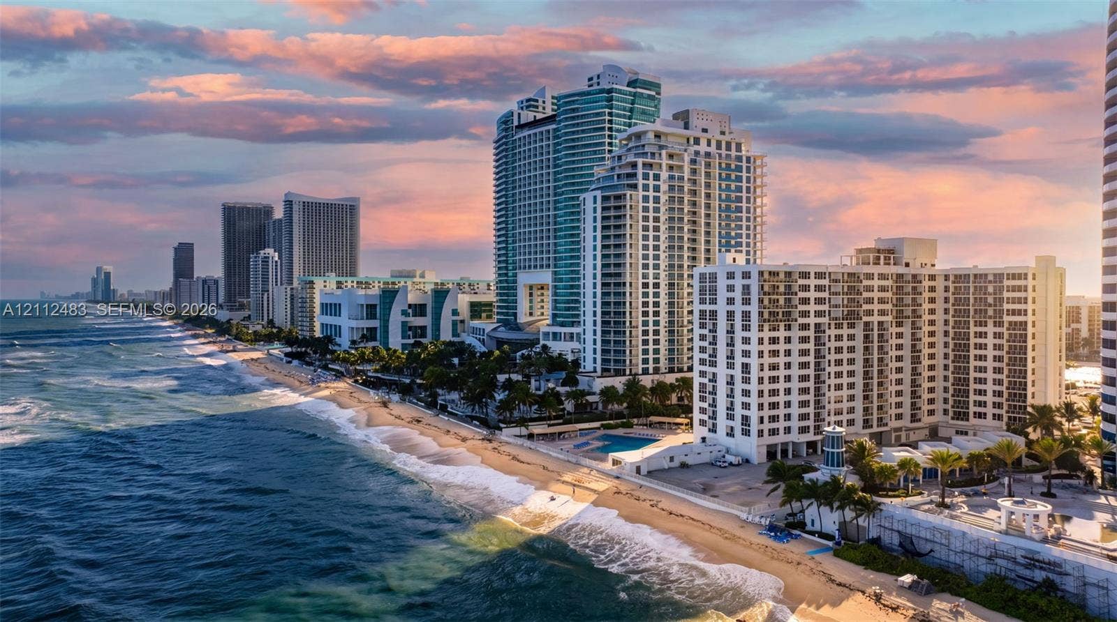 3505 S Ocean Drive, #1101, Hollywood, FL 33019 Coastal high-rise exterior featuring a direct oceanfront location, expansive shoreline, ground-level pool, and palm-lined landscaping