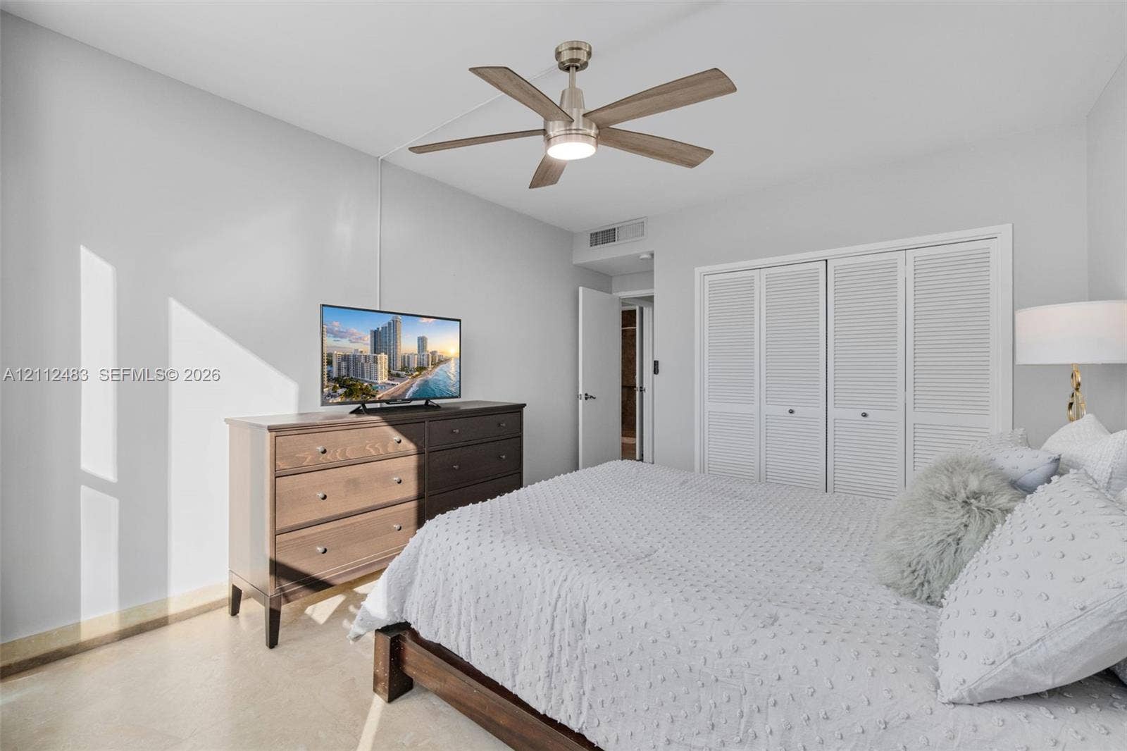 3505 S Ocean Drive, #1101, Hollywood, FL 33019 Room featuring neutral-toned walls, polished concrete flooring, a multi-blade ceiling fan with integrated lighting, and white louvered-panel closet doors