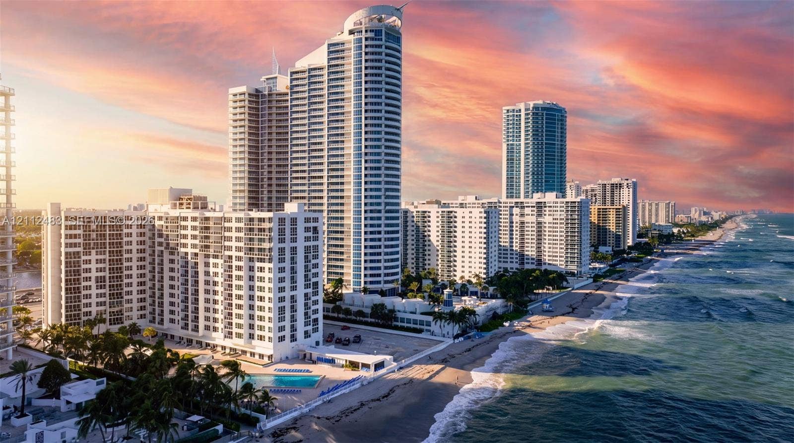 3505 S Ocean Drive, #1101, Hollywood, FL 33019 High-rise residential tower exterior featuring direct oceanfront access, balcony terraces, a ground-level swimming pool, and tropical landscaping