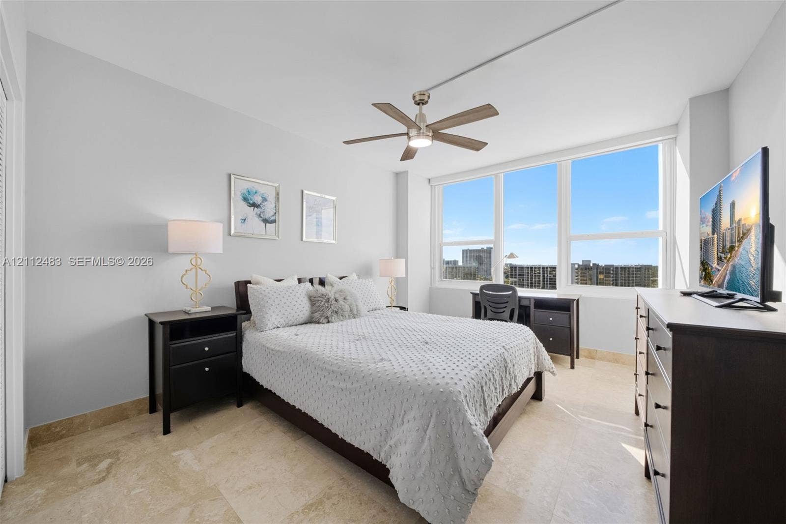 3505 S Ocean Drive, #1101, Hollywood, FL 33019 Neutral-toned tile flooring, floor-to-ceiling windows, and a multi-blade ceiling fan with integrated lighting