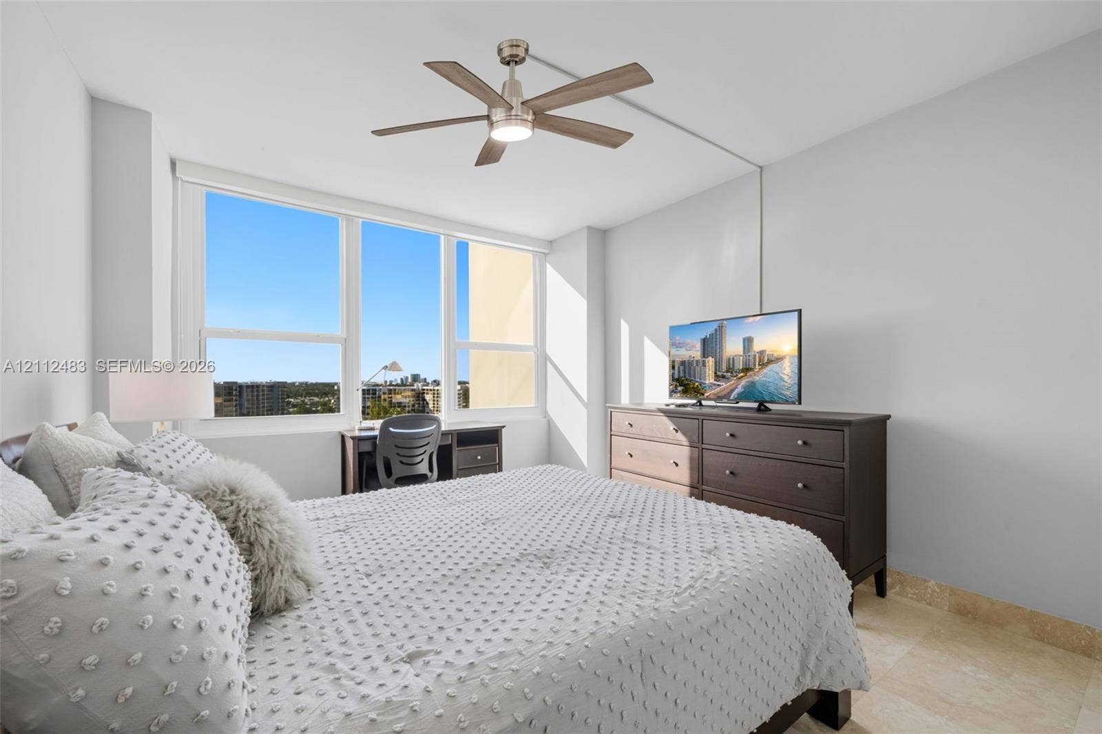 3505 S Ocean Drive, #1101, Hollywood, FL 33019 Large floor-to-ceiling windows, natural stone flooring, and a brushed nickel ceiling fan with integrated lighting
