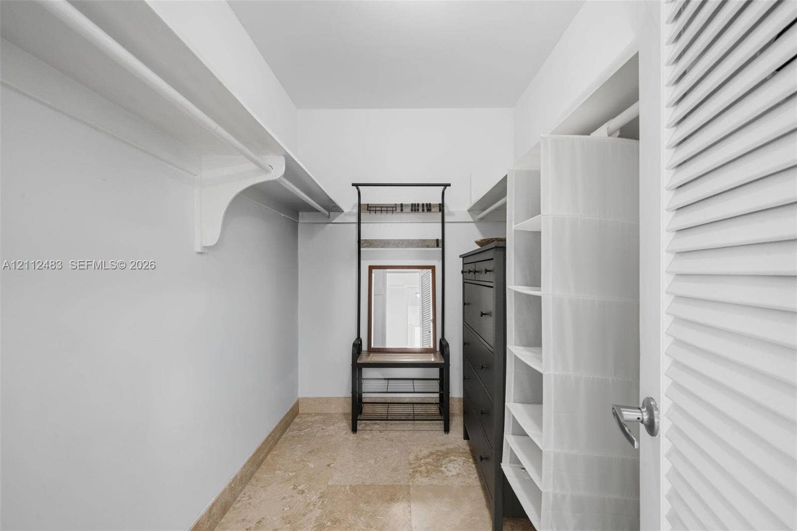 3505 S Ocean Drive, #1101, Hollywood, FL 33019 Walk-in closet featuring stone-tiled flooring and extensive built-in shelving with overhead hanging racks