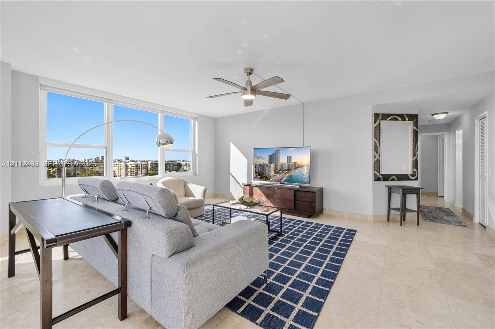 3505 S Ocean Drive, #1101, Hollywood, FL 33019 Living area featuring large-format tile flooring, a neutral color palette, a ceiling fan, and expansive windows with exterior scenery