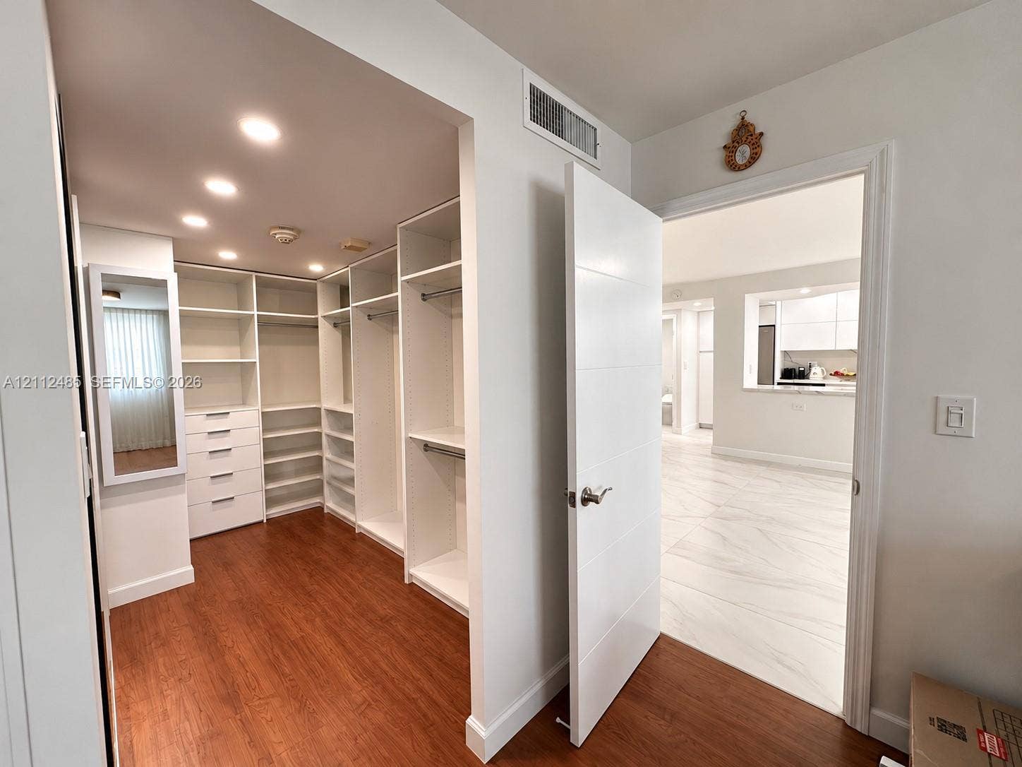 250 174th Street, #1707, Sunny Isles Beach, Sunny Isles Beach, FL 33160 Custom walk-in closet featuring white built-in shelving, integrated dresser drawers, recessed lighting, and wood-finish flooring