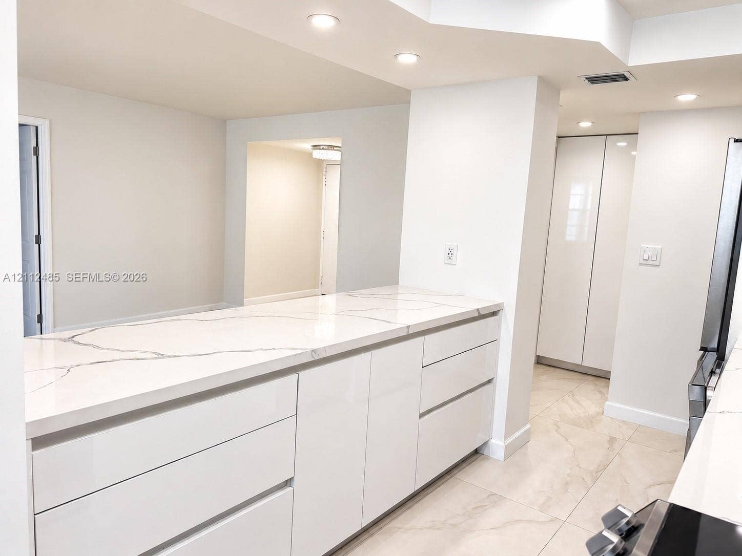 250 174th Street, #1707, Sunny Isles Beach, Sunny Isles Beach, FL 33160 Kitchen featuring high-gloss cabinetry, stone-finish countertops, tile flooring, and integrated recessed lighting