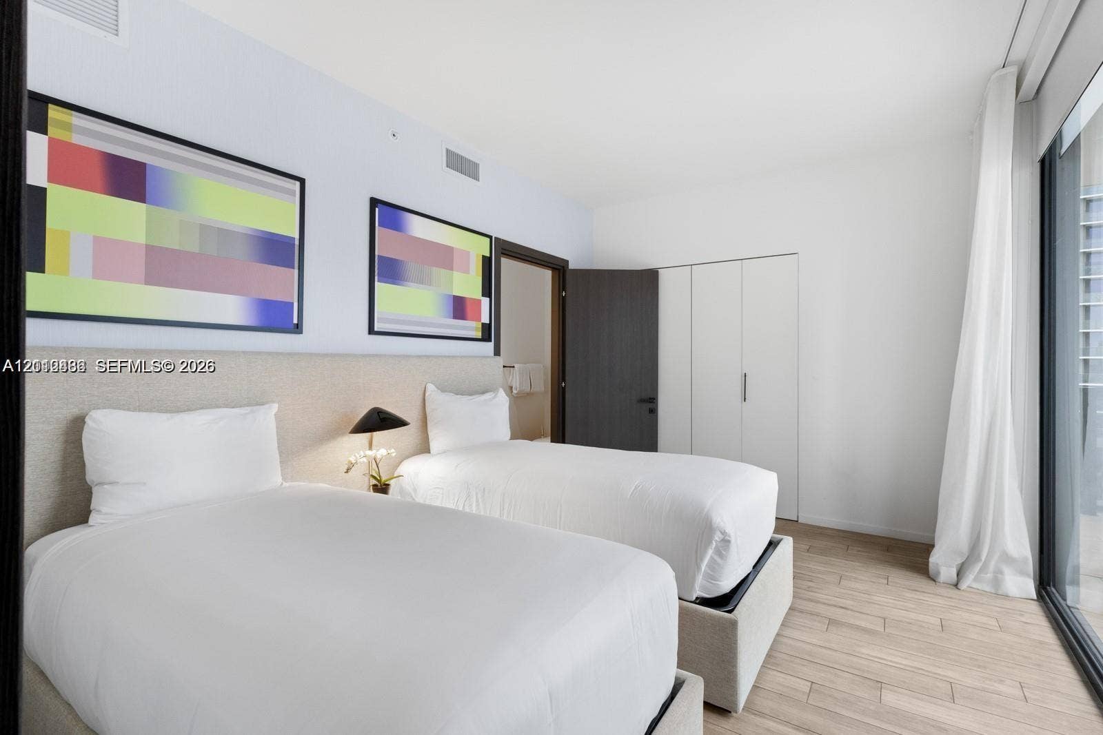 Wood-finish flooring, full-height built-in storage cabinetry, and floor-to-ceiling glass paneling