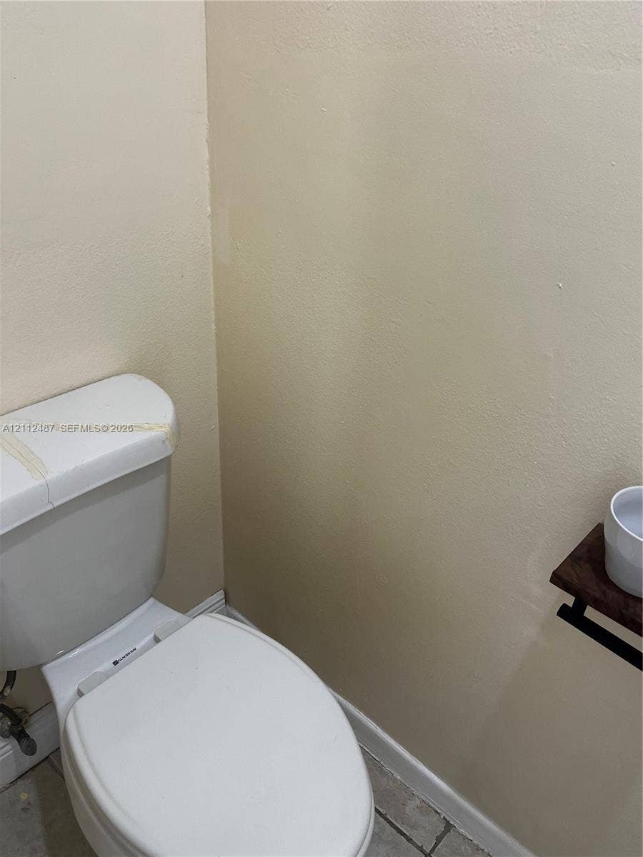White porcelain toilet and wall-mounted wooden shelf fixture