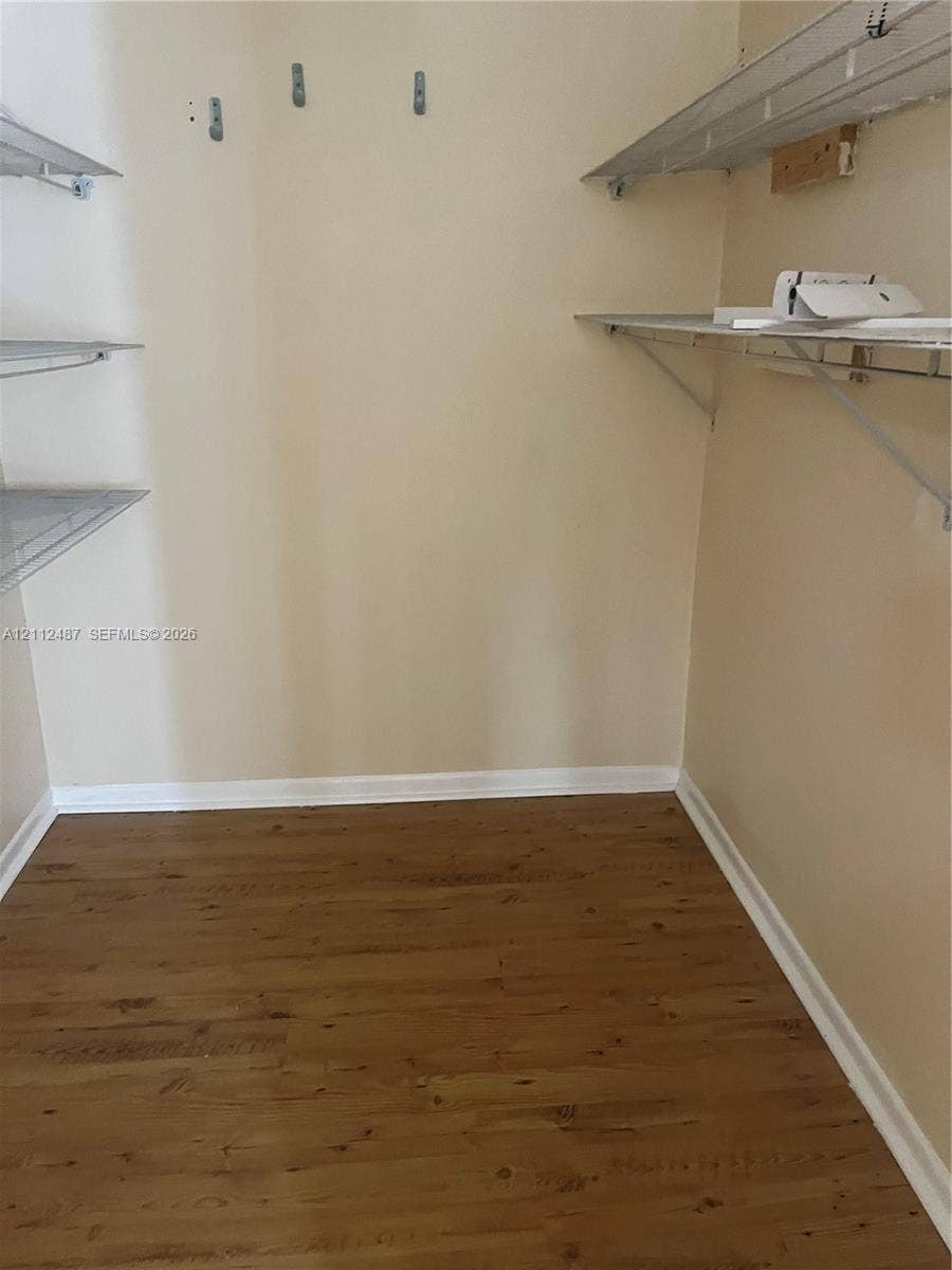 Storage area featuring wood-finish flooring and installed metal shelving units