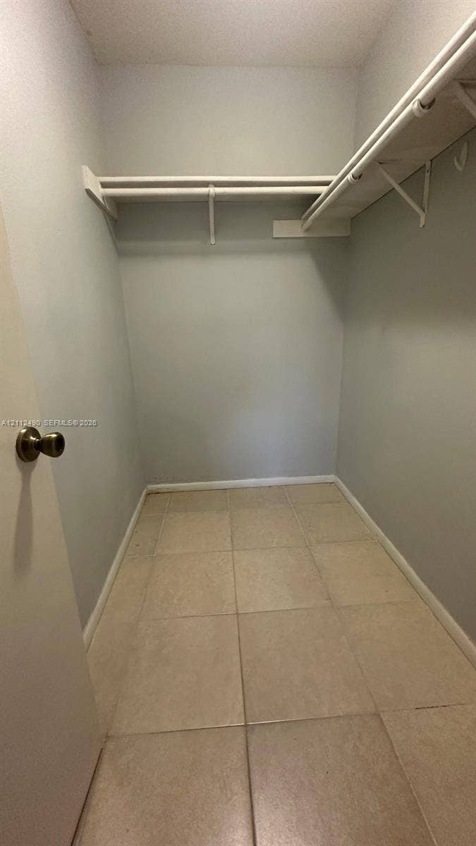 4025 NW 87th Avenue, #4025, Sunrise, Sunrise, FL 33351 Walk-in storage space featuring tiled flooring and upper built-in shelving with integrated rods