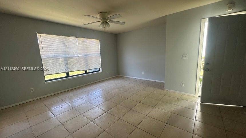 4025 NW 87th Avenue, #4025, Sunrise, Sunrise, FL 33351 Neutral-toned interior featuring large-format tile flooring, a ceiling fan with integrated lighting, and a window with horizontal blinds