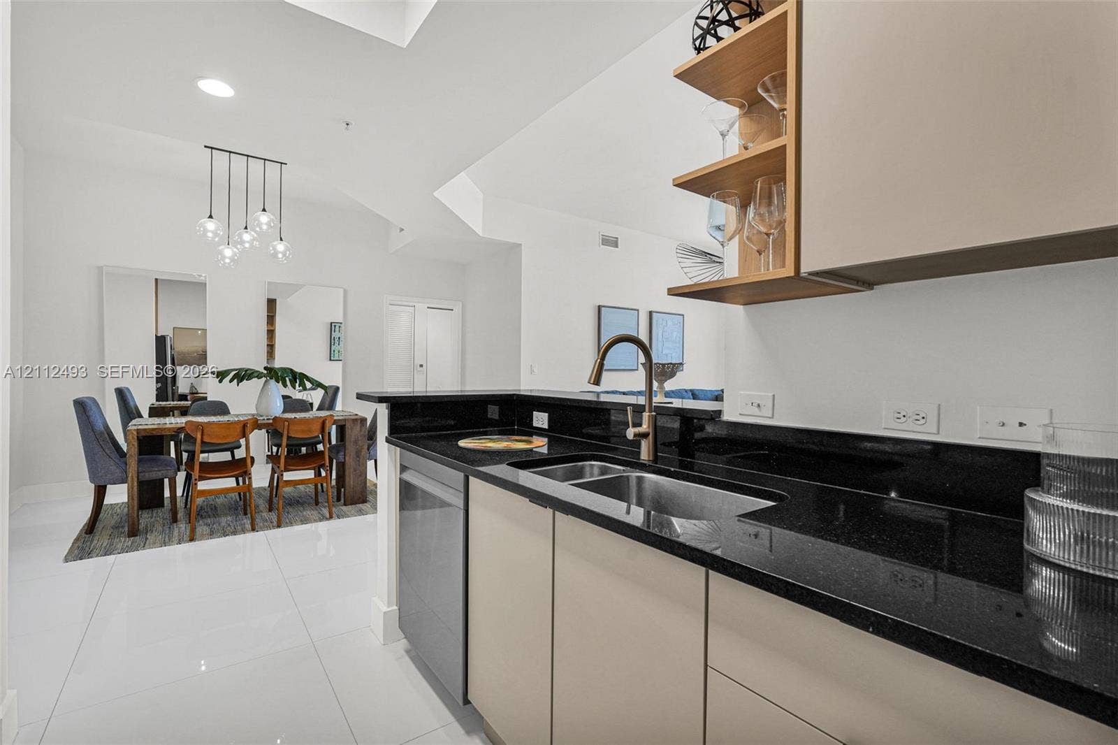 Kitchen featuring slab countertops, undermount sink, matte finish cabinetry, integrated shelving, and large-format tile flooring