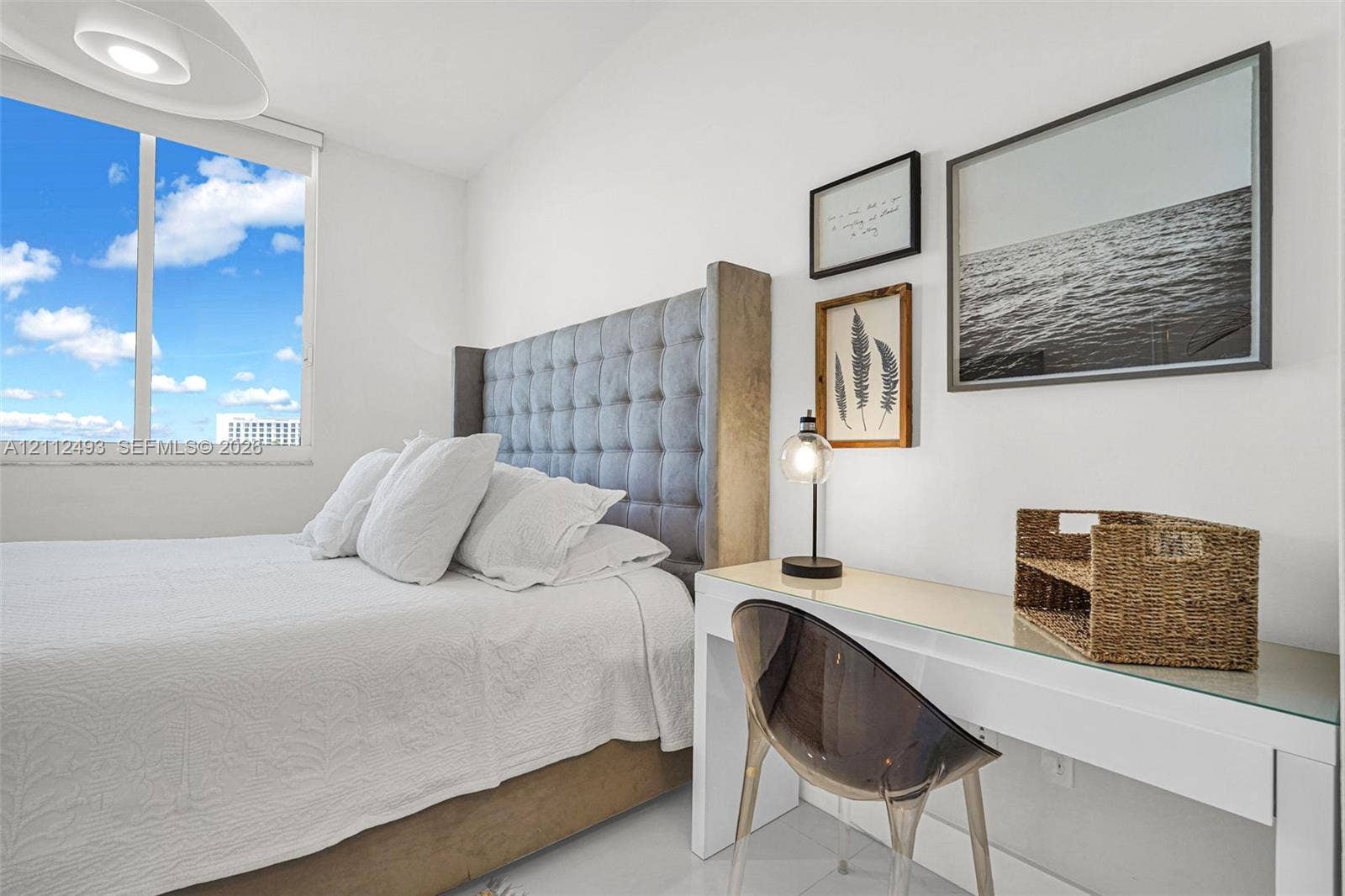 Bright room with large window, vaulted ceiling, and white finish flooring