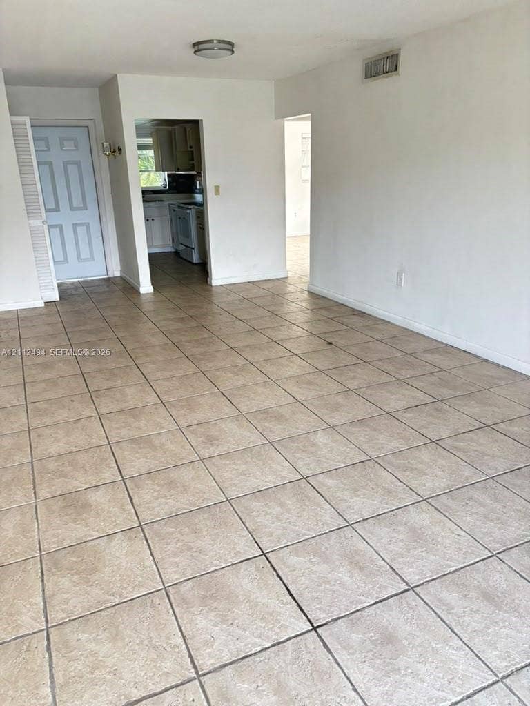 7364 SW 82nd Street, #E207, Miami, Miami, FL 33143 Ceramic tile flooring, neutral wall finishes, and solid-core interior door with louvered closet panel
