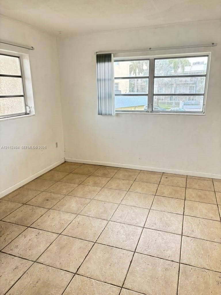 7364 SW 82nd Street, #E207, Miami, Miami, FL 33143 Room featuring light-toned tile flooring, neutral wall finishes, and multiple windows with installed vertical blinds