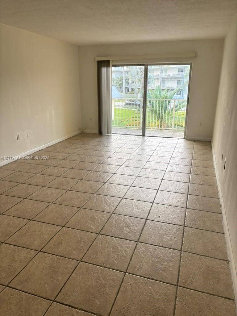 7364 SW 82nd Street, #E207, Miami, Miami, FL 33143 Neutral-toned ceramic tile flooring, sliding glass doors, and a metal-railing balcony