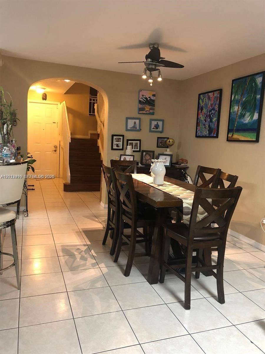 Ceramic tile flooring, arched entryway, and multi-light ceiling fan