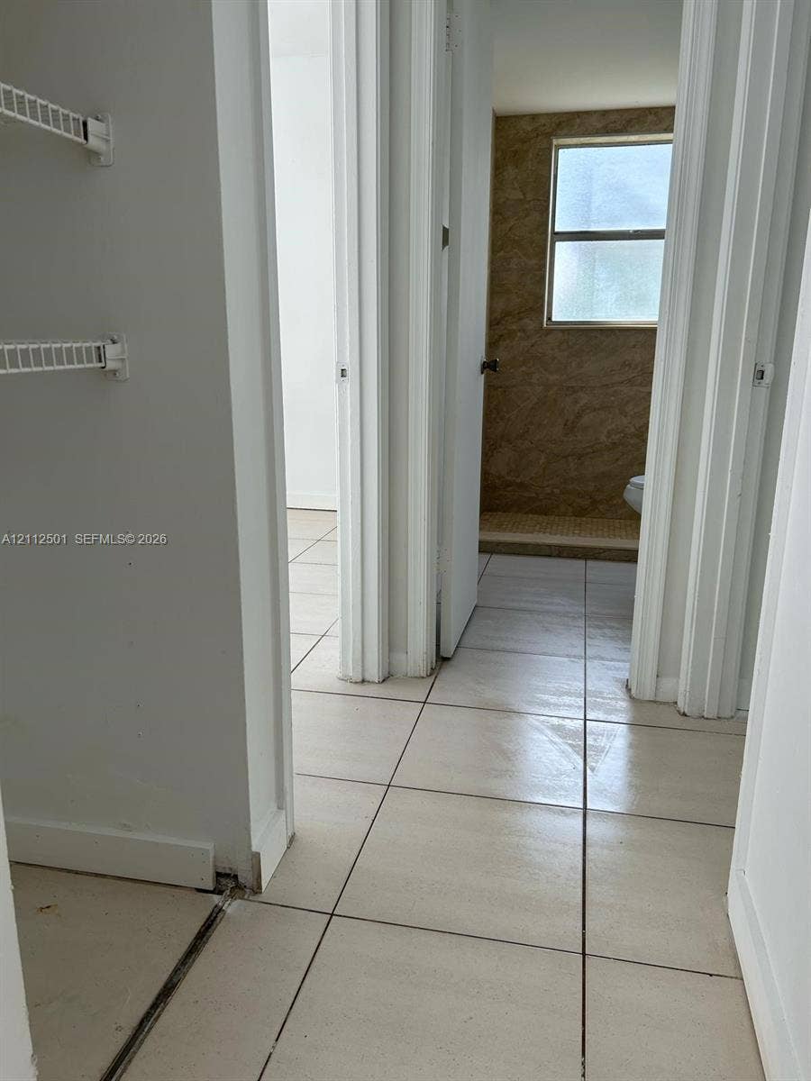 Ceramic tile flooring throughout with wall-mounted wire shelving units