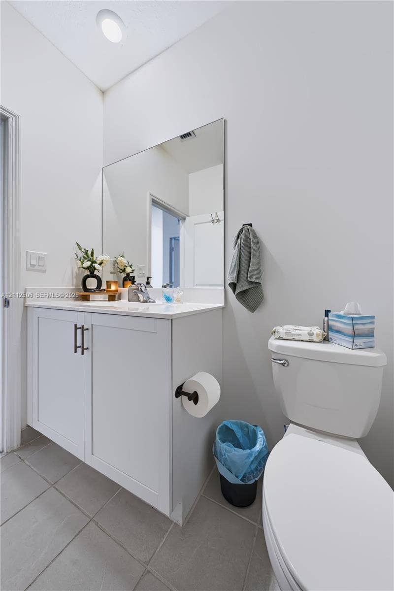 538 SW 19th Terrace, Fort Lauderdale, Fort Lauderdale, FL 33312 Shaker-style white vanity with stone-composite countertop, large wall-mounted mirror, matte black hardware, and neutral tile flooring
