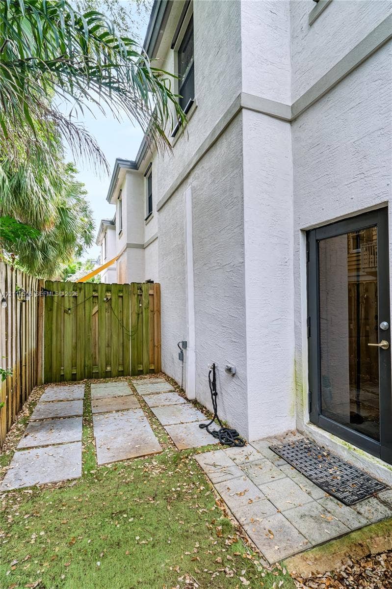538 SW 19th Terrace, Fort Lauderdale, Fort Lauderdale, FL 33312 Exterior side yard featuring stucco siding, stone paver pathway, and enclosed wood fencing
