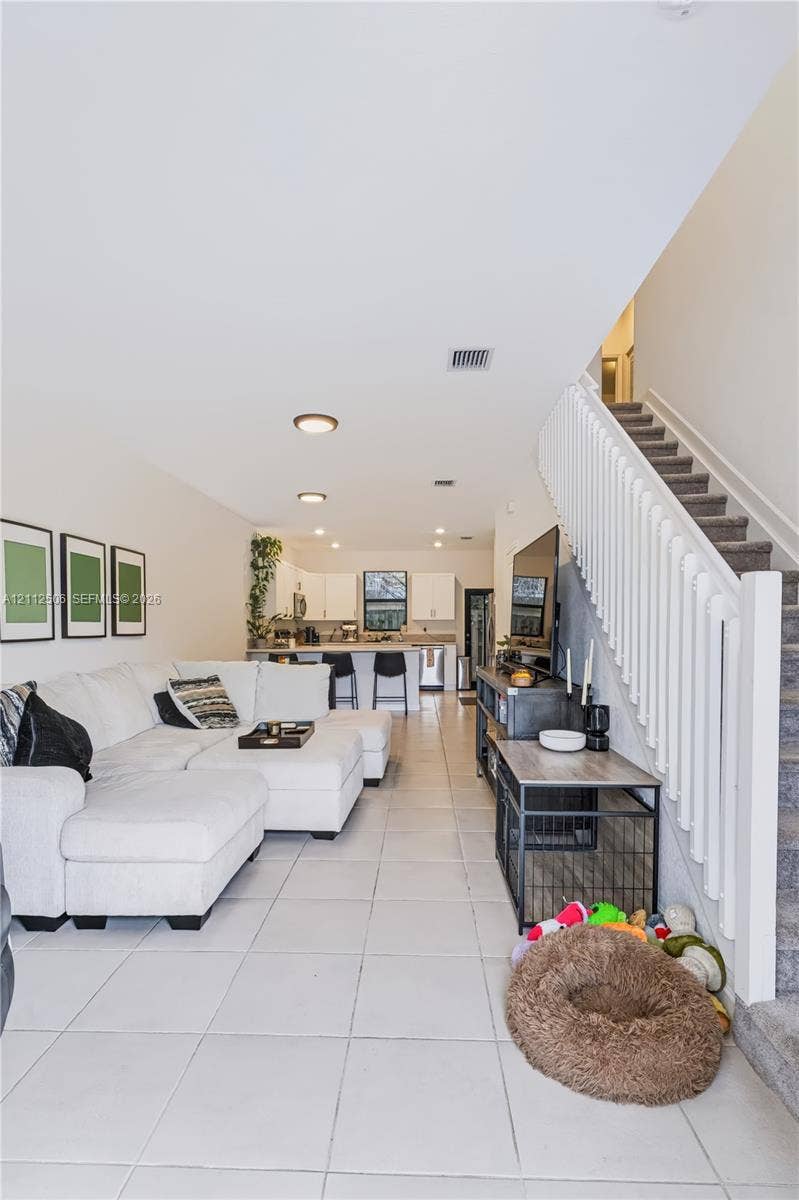 538 SW 19th Terrace, Fort Lauderdale, Fort Lauderdale, FL 33312 Open-concept floor plan featuring tile flooring, white cabinetry, a kitchen island, and a staircase with white balusters