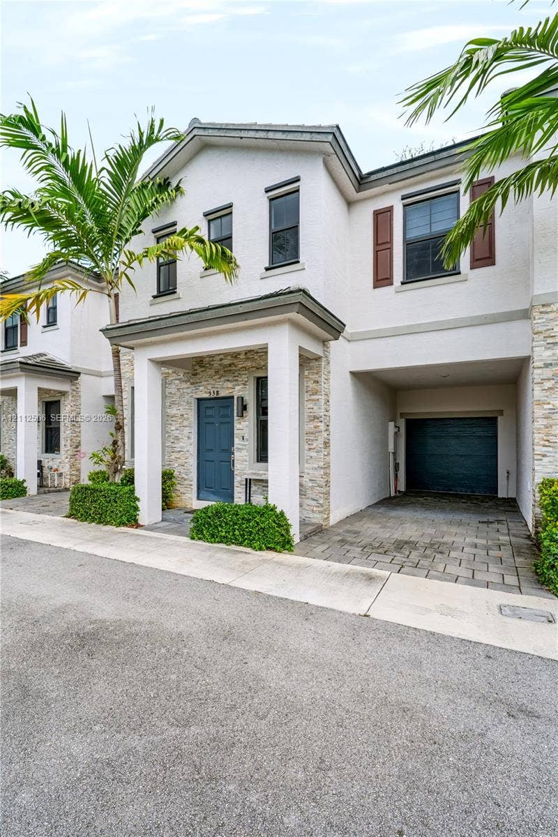 538 SW 19th Terrace, Fort Lauderdale, Fort Lauderdale, FL 33312 Stucco exterior featuring stacked stone veneer accents, covered entryway, paver driveway, and an integrated garage